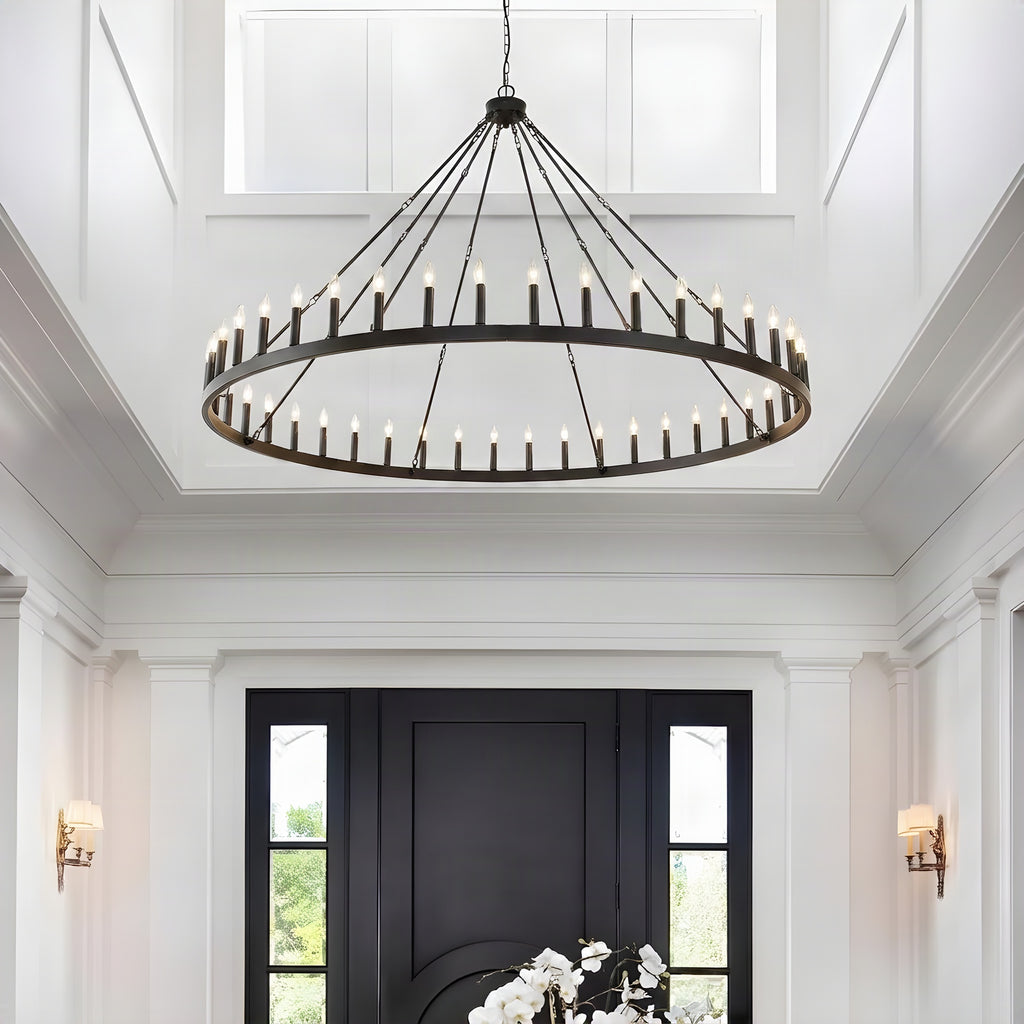 Large black wagon wheel chandelier lighting a two story entryway